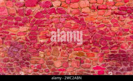 Close-up of the texture of a dark red stone wall. Stock Photo