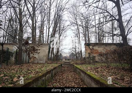 Ditch full of fallen leaves next to a wall in a park in autumn Stock Photo