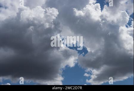 Blue sky with gray cumulus clouds. Solid gray clouds before rain. Stock Photo