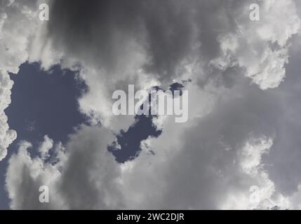 Overcast sky. Solid gray clouds before rain. Low Angle View Of Sunlight Streaming Through Clouds Stock Photo