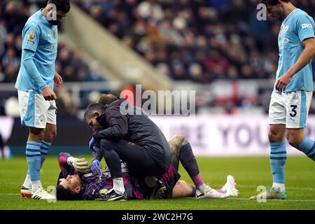 Manchester City goalkeeper Ederson receives treatment for an injury during the Premier League match at St. James' Park, Newcastle upon Tyne. Picture date: Saturday January 13, 2024. Stock Photo