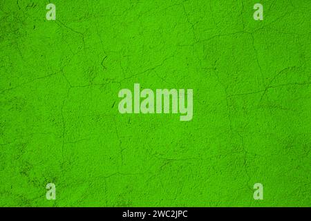 The old rough surface of the wall .Scuffed peeling green plaster on the wall. Stock Photo
