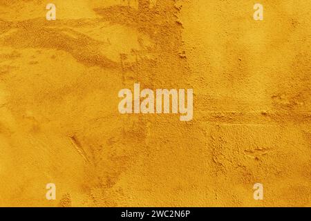 Surface of uneven old plaster on the wall. Close-up surface of yellow plaster. Stock Photo