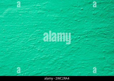 The surface of an unevenly painted green wall. Green Textured Wall Background . Stock Photo