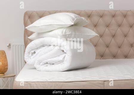 Soft folded duvet and pillows on bed Stock Photo