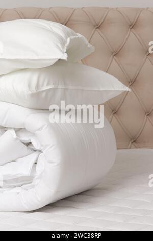 Soft folded duvet and pillows on bed Stock Photo