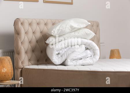 Soft folded duvet and pillows on bed Stock Photo
