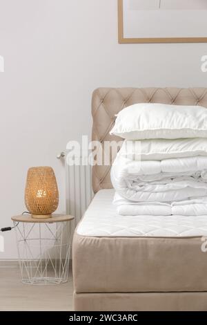 Soft folded duvet and pillows on bed Stock Photo