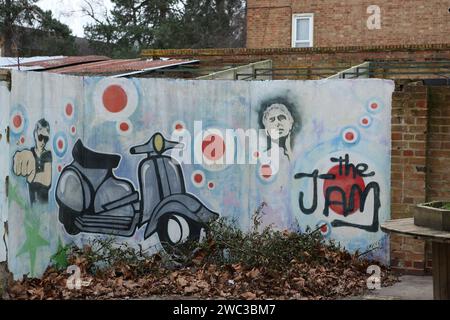 Sheerwater, Woking, Surrey. Wall mural with graffiti showing Paul Weller and scooter and name of The Jam Stock Photo