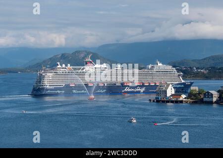 The Mein Schiff 1 (TUI) cruise ship departing Alesund in Norway with a fire boat spraying water as part of the sail away tradition. Stock Photo