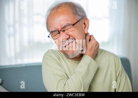 Old man suffering from nape neck pain at home Stock Photo - Alamy
