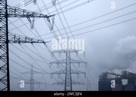 Strommasten stehen auf einem Feld in der Nähe von Industrieanlagen bei Köln. Unternehmen aus allen Branchen klagen über hohe Strompreise. Verschärft hat sich das seit dem Ukraine-Krieg und der darauf folgenden Energiepreiskrise. Themenbild, Symbolbild. Köln, 13.01.2024 NRW Deutschland *** Electricity pylons stand in a field near industrial plants near Cologne Companies from all sectors are complaining about high electricity prices This has worsened since the war in Ukraine and the subsequent energy price crisis Themed image, symbolic image Cologne, 13 01 2024 NRW Germany Copyright: xChristophx Stock Photo