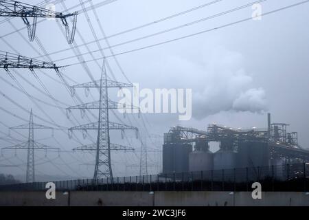 Strommasten stehen auf einem Feld in der Nähe von Industrieanlagen bei Köln. Unternehmen aus allen Branchen klagen über hohe Strompreise. Verschärft hat sich das seit dem Ukraine-Krieg und der darauf folgenden Energiepreiskrise. Themenbild, Symbolbild. Köln, 13.01.2024 NRW Deutschland *** Electricity pylons stand in a field near industrial plants near Cologne Companies from all sectors are complaining about high electricity prices This has worsened since the war in Ukraine and the subsequent energy price crisis Themed image, symbolic image Cologne, 13 01 2024 NRW Germany Copyright: xChristophx Stock Photo