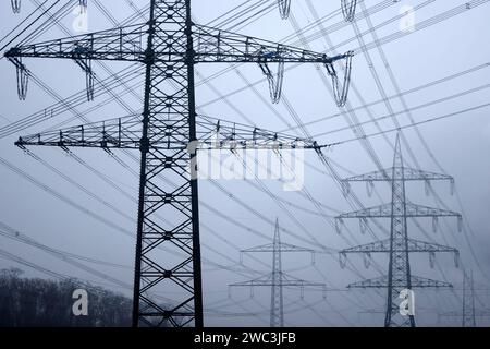 Strommasten stehen auf einem Feld in der Nähe von Industrieanlagen bei Köln. Unternehmen aus allen Branchen klagen über hohe Strompreise. Verschärft hat sich das seit dem Ukraine-Krieg und der darauf folgenden Energiepreiskrise. Themenbild, Symbolbild. Köln, 13.01.2024 NRW Deutschland *** Electricity pylons stand in a field near industrial plants near Cologne Companies from all sectors are complaining about high electricity prices This has worsened since the war in Ukraine and the subsequent energy price crisis Themed image, symbolic image Cologne, 13 01 2024 NRW Germany Copyright: xChristophx Stock Photo