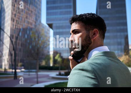 Young handsome Caucasian business man walking talking on phone serious expression. Male professional Stock Photo