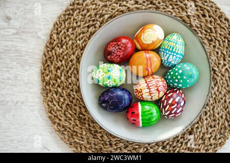 Colorful Easter eggs hand-painted at home. Using food coloring to dye Easter eggs. Painting eggs with candle wax. Getting ready for Easter egg hunt. F Stock Photo