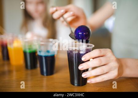 Using food coloring to dye Easter eggs at home. Painting colorful eggs for Easter hunt. Getting ready for Easter celebration. Family traditions. Stock Photo