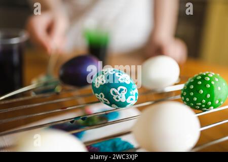 Using candle wax to dye Easter eggs at home. Painting colorful eggs for Easter hunt. Getting ready for Easter celebration. Family traditions. Stock Photo