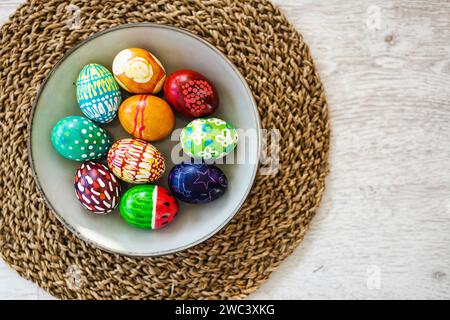 Colorful Easter eggs hand-painted at home. Using food coloring to dye Easter eggs. Painting eggs with candle wax. Getting ready for Easter egg hunt. F Stock Photo