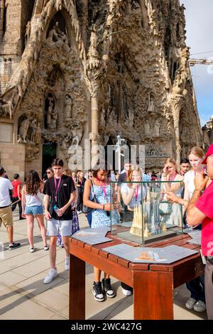 Tourist guide tour, tourists in front of La Sagrada Família Cathedral Nativity facade looking at a model showing the church stages of construction Stock Photo