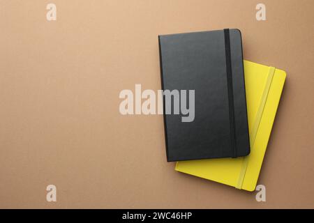 Different notebooks on light brown background, top view. Space for text Stock Photo