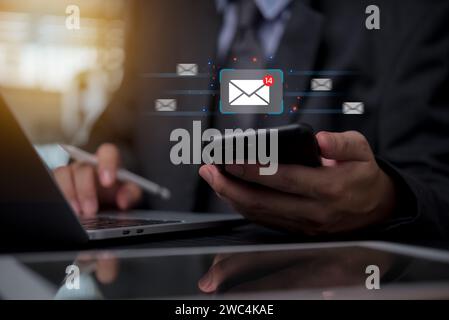 Businessman holding mobile phone icon email send digital technology marketing message communications and invite contact online electronic newsletter. Stock Photo