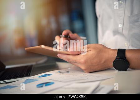 Businessman working with tablet presentation analyzing data planning documents graphs and chart on desk Stock Photo