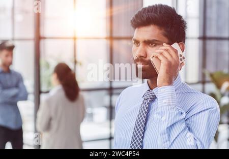 professional businessman executive entrepreneur wearing holding telephone making corporate call on cellphone. Stock Photo