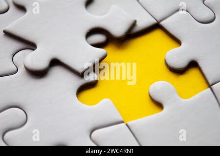 Close up view of missing jigsaw puzzle on yellow background. Copy space Stock Photo