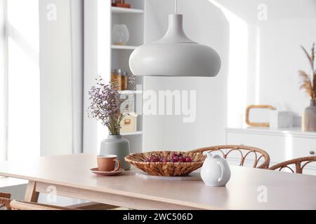 Dining table with dried lavender, grapes and tea in light room Stock Photo