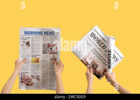 Women with newspapers on yellow background Stock Photo