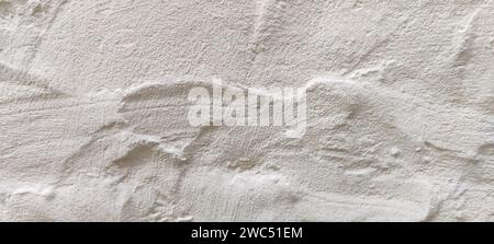 The rough texture of a poorly plastered light-colored wall. An uneven surface with bumps and depressions. Background for the design. Full frame. Copy Stock Photo
