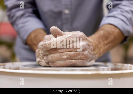 male hands making ceramic cup on pottery wheel, Close-up Stock Photo