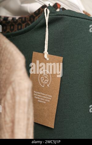 Close up of clothing tag with recycle icon. Recycling products concept. Zero waste, suistainale production, environment care and reuse concept. Stock Photo