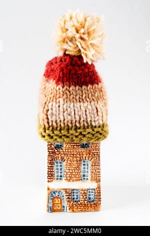 A model house wearing a woolly knitted bobble hat to keep warm.  Keeping the house warm. Stock Photo