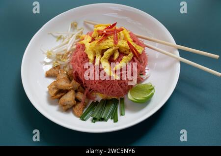 Thai Dish of Stir Fried Pink Vermicelli with Omelette, Bean Sprout, Chives, White Sausage and Lime Stock Photo