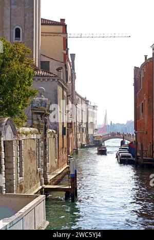 Venice colorful corners with iron bridges, old buildings and architecture, boats and beautiful water reflections on narrow canal, Italy Stock Photo