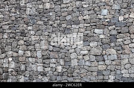 a stone wall made of natural stone background Stock Photo