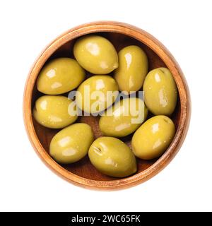 Green olives with pit, pickled whole, large Greek table olives, in a wooden bowl. Whole fruits, picked when they are still unripe and of bitter taste. Stock Photo