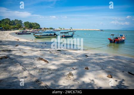 Fishing boats on the sea and beach of George Town city in the distance on the Strait of Malacca in Penang, Malaysia.  Stock Photo