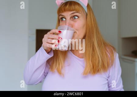 Middle aged woman drinking yogurt Stock Photo
