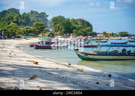 Fishing boats on the sea and beach of George Town city in the distance on the Strait of Malacca in Penang, Malaysia.  Stock Photo