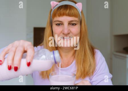Middle aged woman drinking yogurt Stock Photo