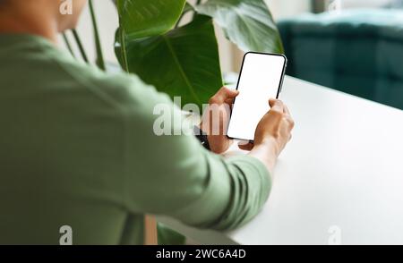 Over shoulder view black guy using phone with blank screen Stock Photo