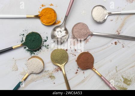 Different types of dietary supplements for health and beauty - collagen, vitamins, biotin, protein powder in spoons Stock Photo