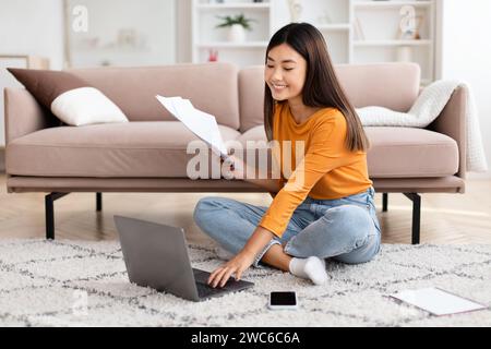 Chinese lady freelancer working from home, using laptop Stock Photo