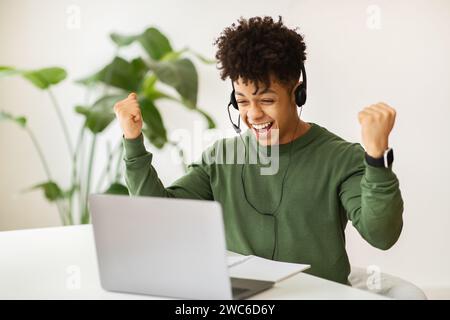 Excited black guy remote employee working at cafe Stock Photo