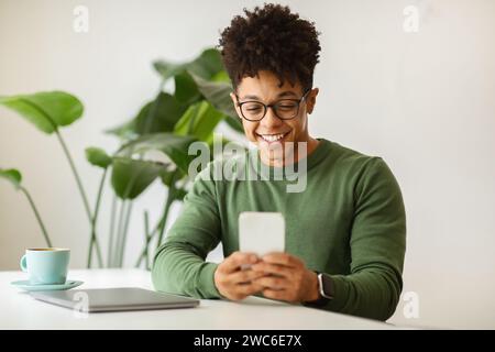 Happy young black guy freelancer working at cafe Stock Photo