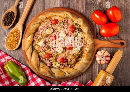 Artisanal pizza. Top view of delicious rustic pizza with ingredients. Stock Photo