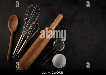 kitchen utensils on black background, seen from above. Stock Photo